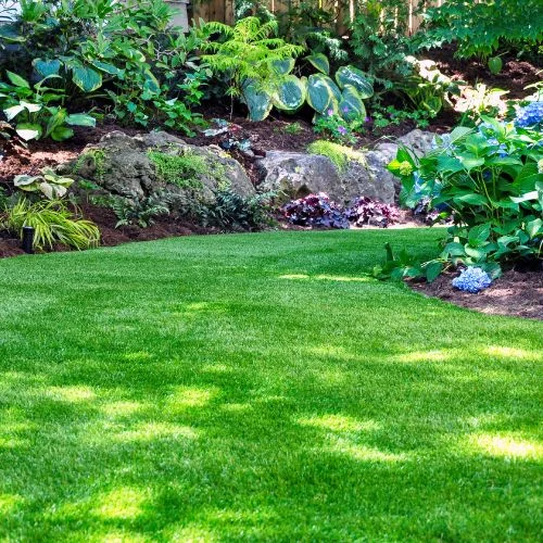 A synthetic lawn in Orange County with flower beds at the sides