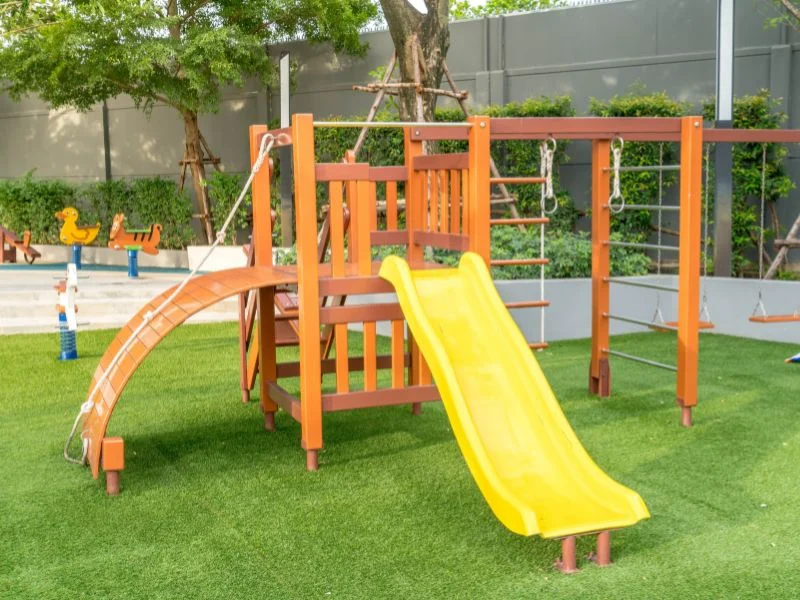 Slide and swings on artificial grass turf in Orange County Ca