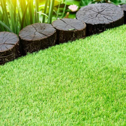A fake lawn with wooden log border at a home in Costa Mesa CA